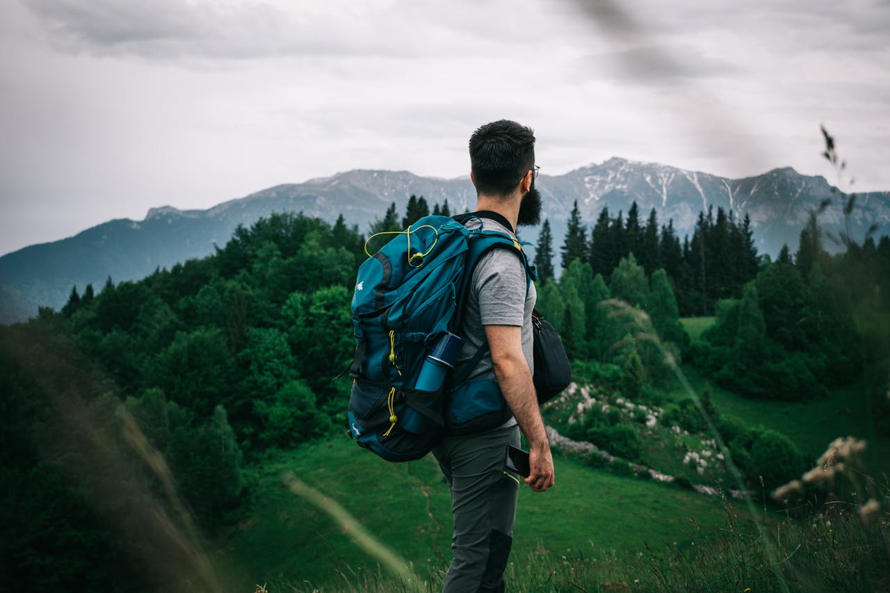 A male hiker explores lush Romanian mountain scenery, embodying adventure and exploration.